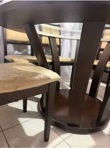 Mesa redonda com tampo em vidro em imbuia, com espaço para 8 cadeiras. Medida 1,40x1,40