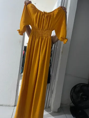 Vestido longo na cor mostarda, longo com fenda lateral.