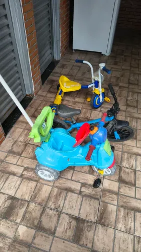 2 Triciclo, bicicleta de equilíbrio e uma caixa de carrinhos usados