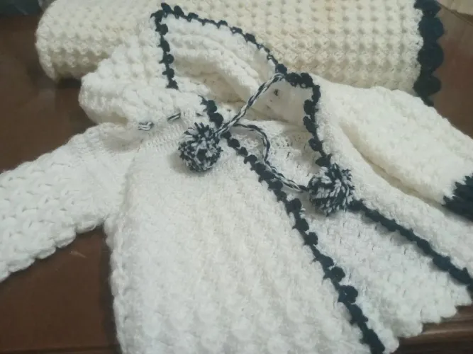 Casaquinho de nenê e a coberta feita a mão