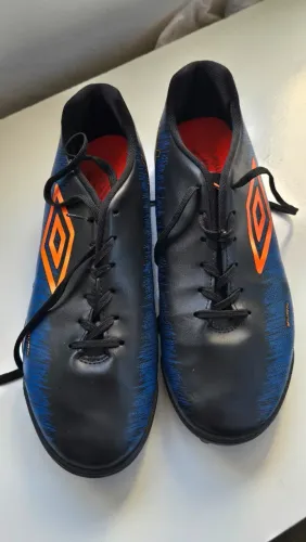 Chuteira Umbro modelo Burn Society, nas cores preto e azul, em ótimo estado de conservação