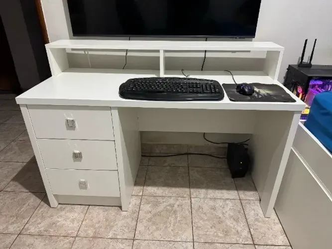 Escrivaninha branca com gavetas e suporte para monitor
