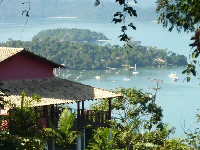 CASA ABRAÇADA PELA MONTANHA COM VISTA PARA O MAR