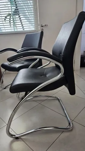 Duas cadeiras interlocutor em corino preto com estrutura metálica cromada em balanço