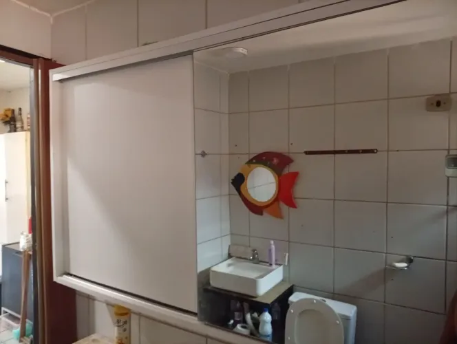Armário de banheiro com porta de correr espelhada e partileira