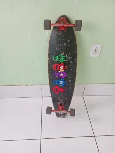 Skate longboard, truck invertido vermelho, pads angulares e rodinha de silicone.