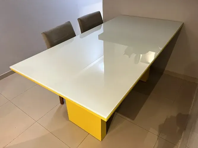 Mesa de jantar amarela com duas cadeiras na cor cinza