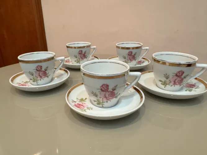 Conjunto de xícaras e pires de porcelana antigos com detalhes florais e dourados
