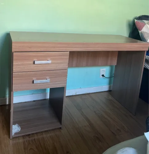 Escrivaninha de madeira com gavetas e espaço para organização. 