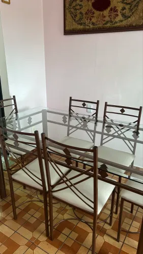 Mesa tampo de vidro e cadeiras de ferro e aparador