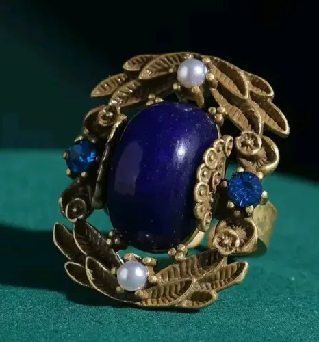 Anel com pedra azul e detalhes. 