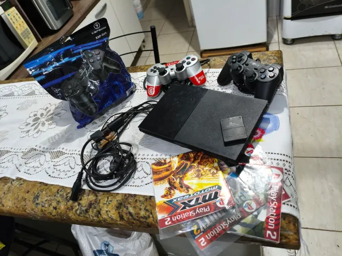 PS2, CONTEM 3 CONTROLES E 4 JOGOS, 1 DOS CONTROLES ESTA LACRADO