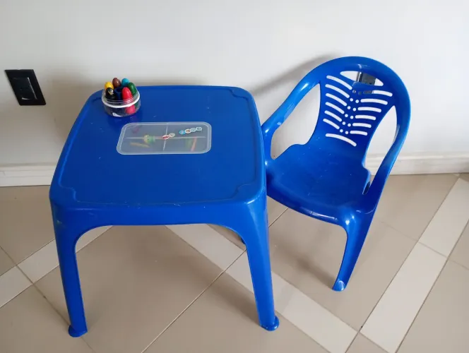Mesa infantil azul com porta lápis.
