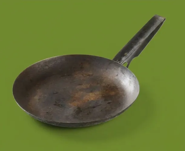 Frigideira em ferro antiga com desgastes e ferrugem.