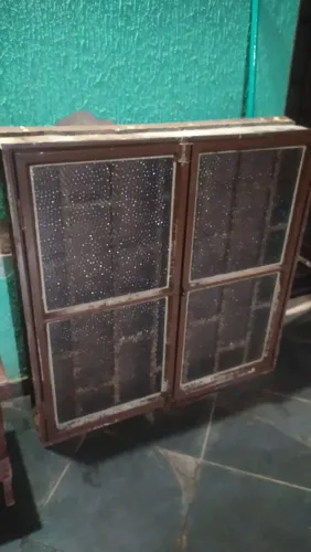 Janela de ferro com grade metálica e vidros texturizados
