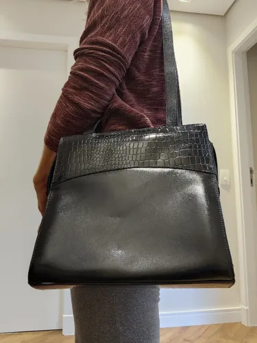 Bolsa de couro preta, com detalhe em verniz