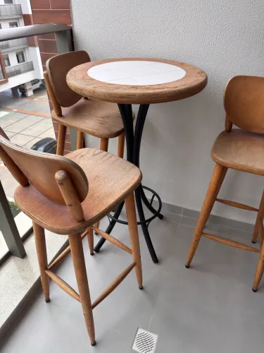 Mesa alta de varanda com três banquetas