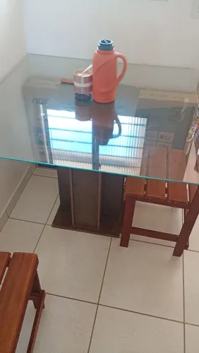 Mesa de vidro com quatro cadeiras em madeira