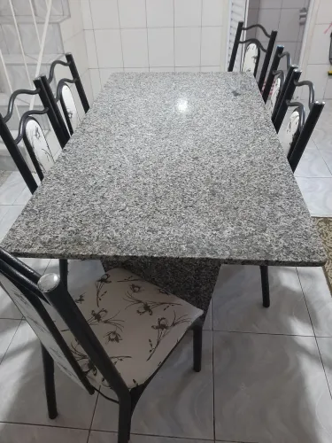 Mesa de cozinha de mármore com 6 cadeiras. Tanto a base como os pés são de mármore.