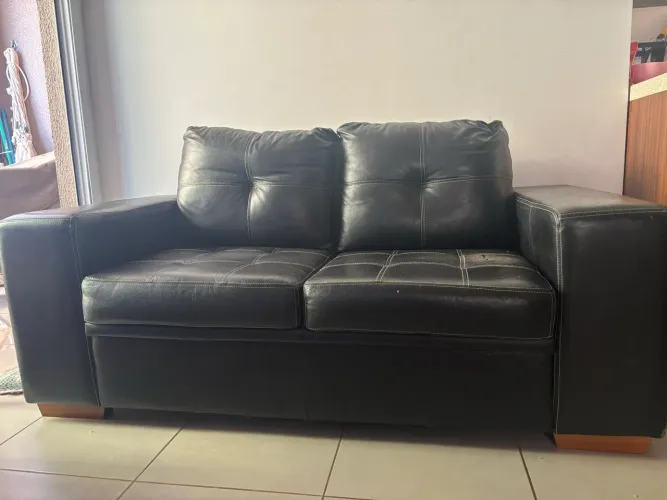 Sofá preto de couro, dois lugares, com pés de madeira