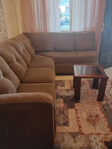 Sofá de canto com mesinha de vidro
