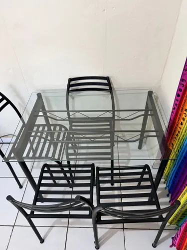 Mesa de vidro e cadeiras de ferro