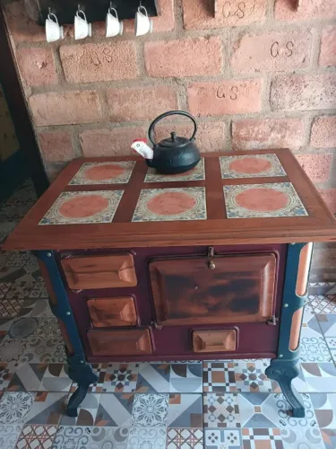 Fogão decorativo de ferro fundido com peroba e tampo de azulejo italiano
