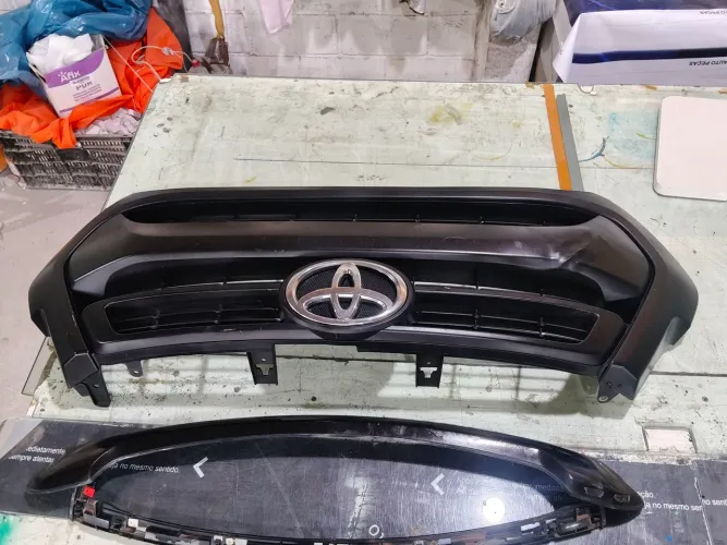 Grade frontal com friso do capô Hilux 2021 preta em ótimo estado.