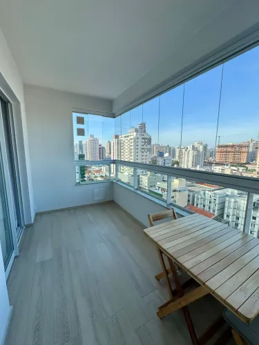 Apartamento com varanda gourmet fechada em vidro e vista parcial para o mar no Kobrasol