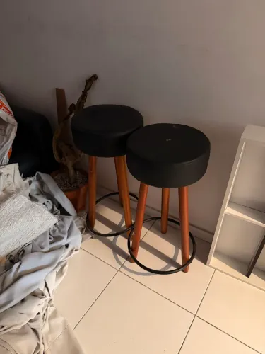 2 banquetas pretas com pés de madeira