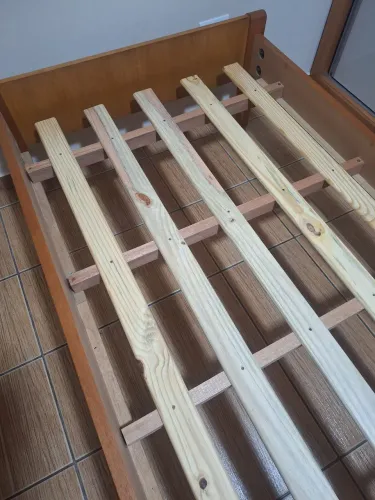 Cama em madeira maciça solteiro seminova com 94,8 cm de largura sem cabeceira.