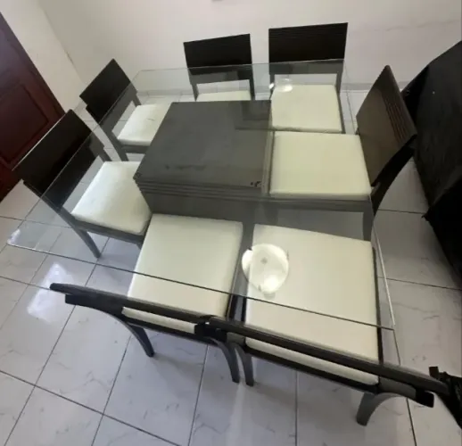 Mesa de jantar em madeira maciça cor tabaco com vidro grosso e 7 cadeiras tbm maciças .