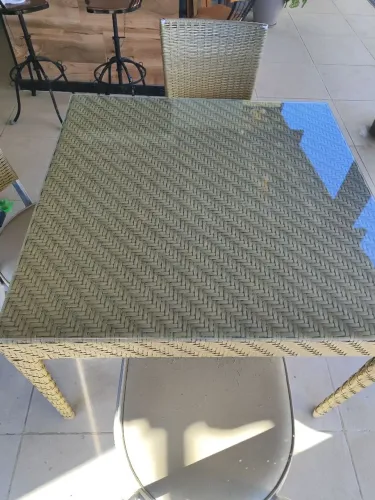 Mesa de fibra sintética com quatro cadeiras acolchoadas