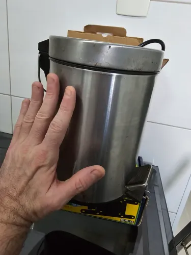 Lixeira de inox pequena de pé.