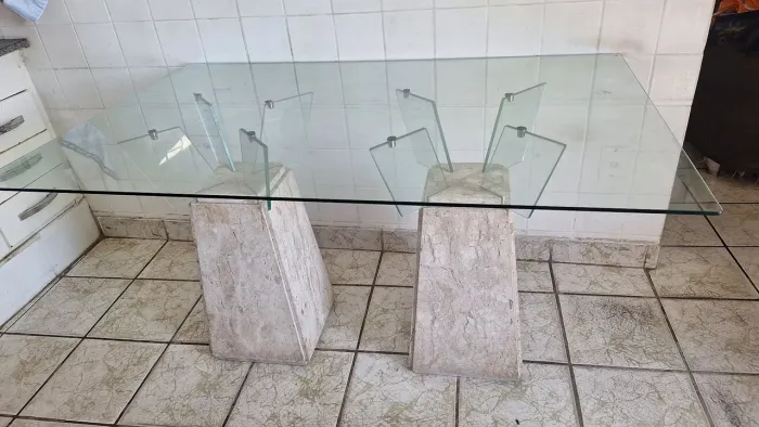 Mesa de jantar com tampo de vidro e pés de mármore 
