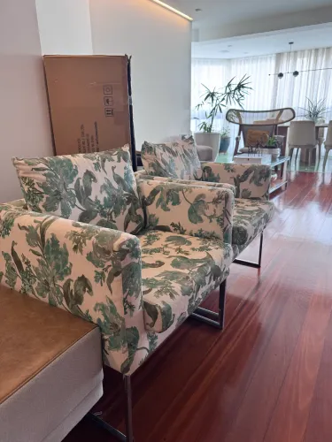 Poltrona Lider com pernas em aço inox e assento em tecido com estampa floral azul