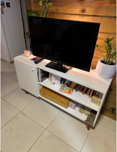 Rack baixo branco para TV, com nichos e portas.