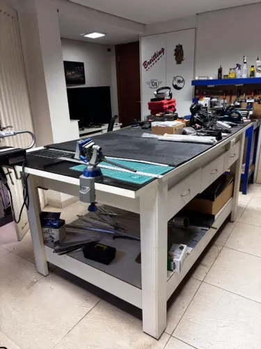 Mesa/bancada de trabalho multiuso com estrutura branca, tampo preto e gavetas