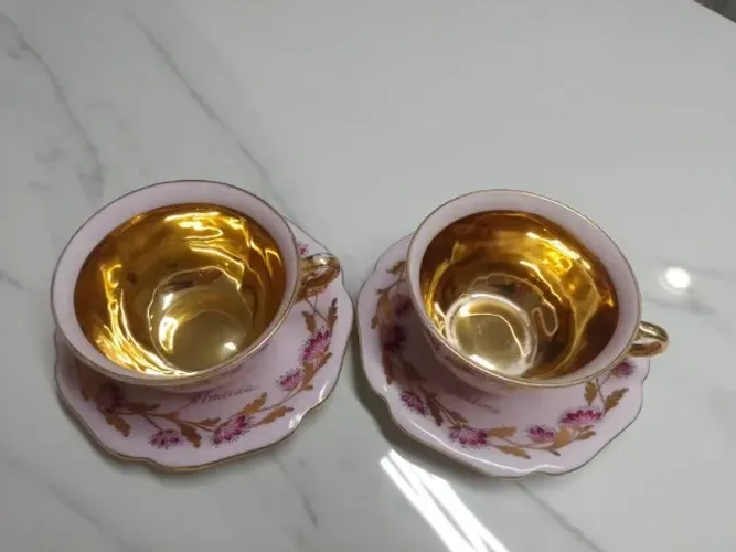 Jogo de duas xícaras pintadas à mão com detalhes em ouro. 