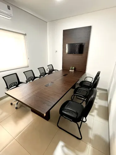Mesa de reunião com cadeiras e painel