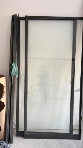 Porta de correr de vidro possui uma esquadria de alumínio na cor preta