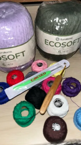 Linhas diversas de crochê e duas agulhas