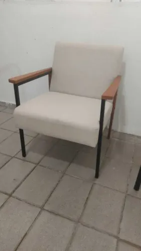 Poltronas de linho com estrutura em metal e detalhes em madeira.