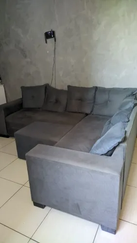Sofá L com puff aveludado cinza