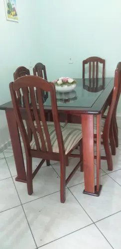 Uma mesa é 6 cadeiras de madeira e vidro