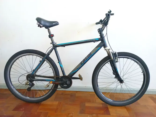 Bicicleta Caloi HTX Aro 26 (Mountain Bike). Cor preta com grafismos em azul.