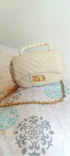 Mini Bolsa em tom bege e detalhes dourado.