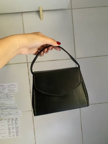 Bolsa pequena preta com avaria na alça
