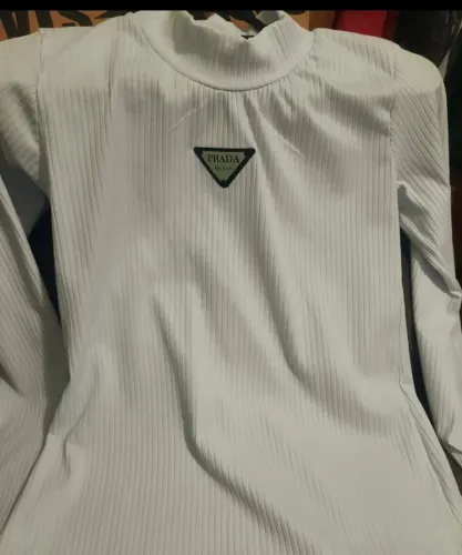 Blusa canelada na cor branca com gola alta e manga longa.