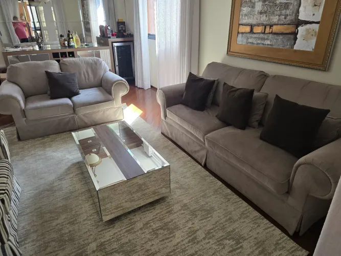 Jogo de sofa, sendo 1 com dois lugares, e outro com 3 lugares e mesa de centro em vidro.